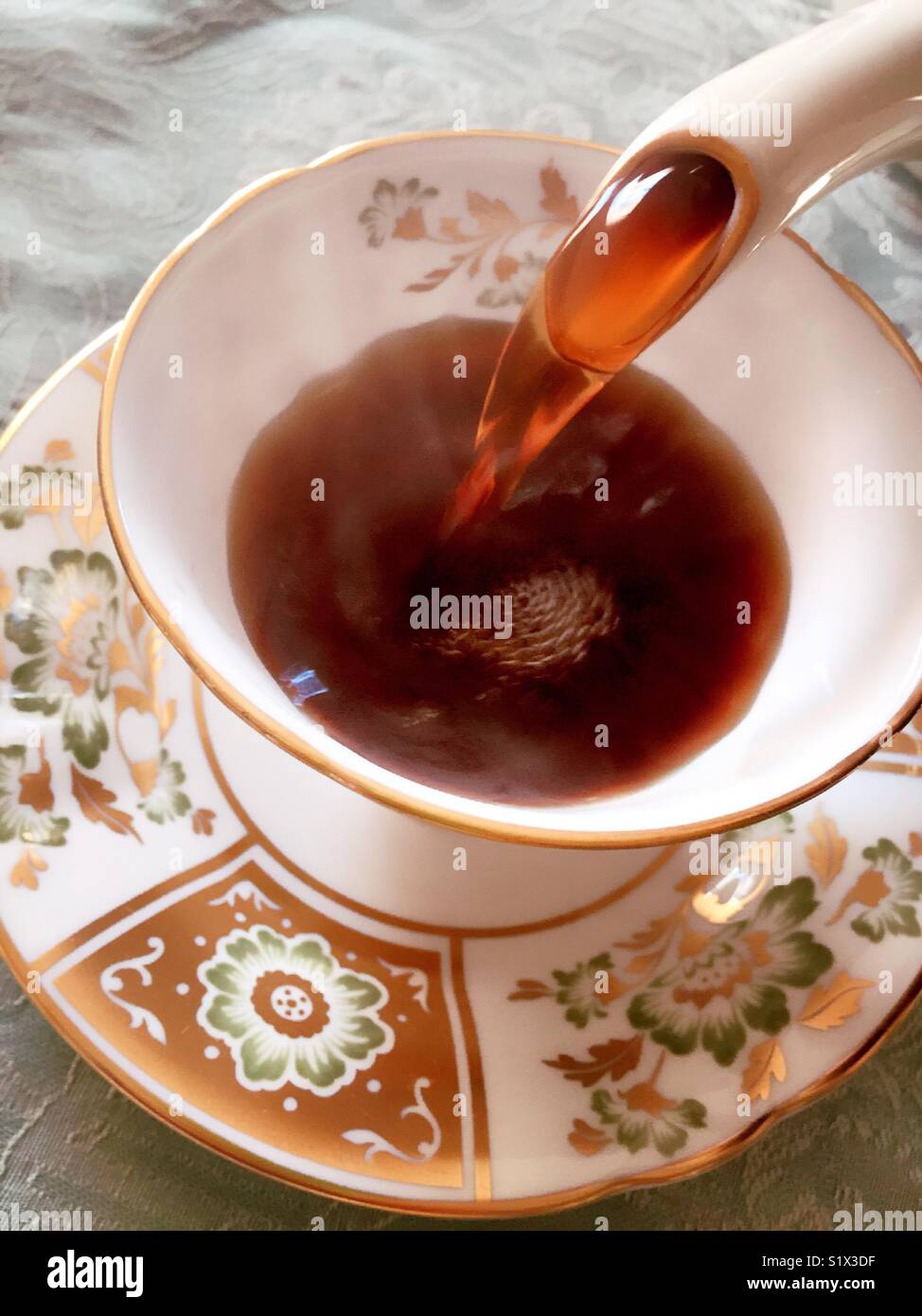 Pouring coffee into an English Royal Crown Derby china cup. - Smartphone Captured Stock Image