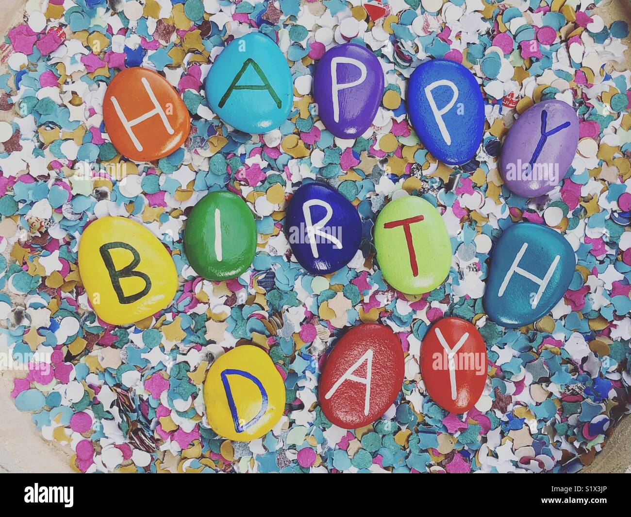 Happy Birthday with multicolored stones and confetti background Stock Photo