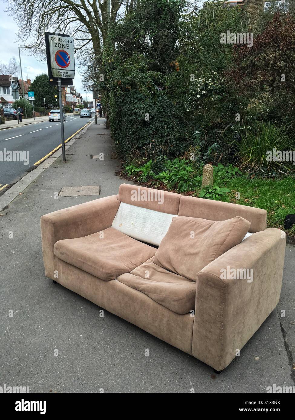 A sofa dumped on the pavement in London, England Stock Photo