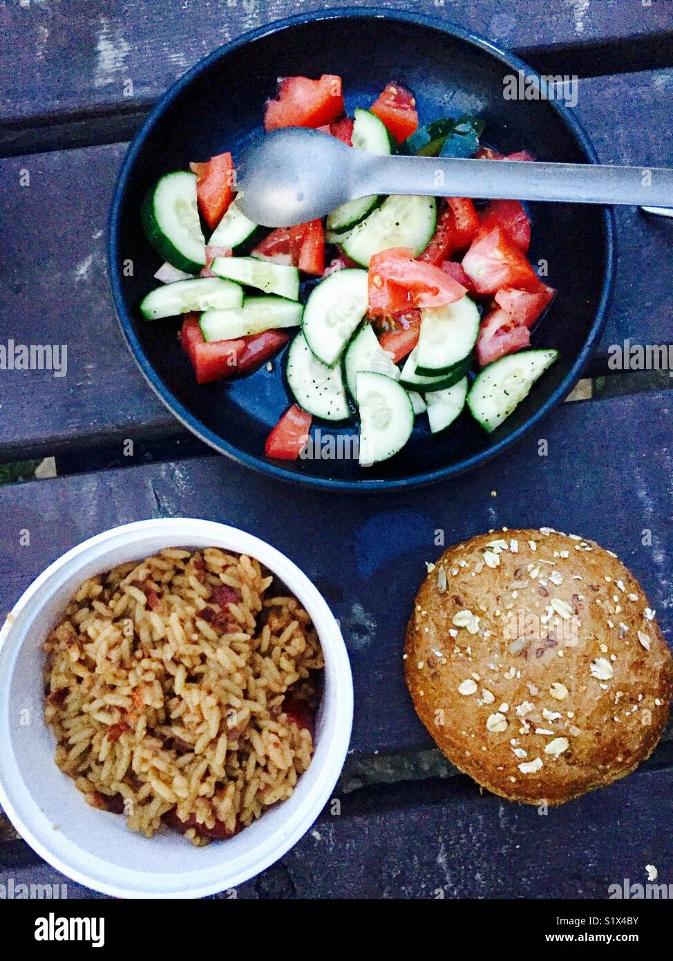 Rustic camp food on an outdoor table with bread, vegetables and rice - Smartphone Captured Stock Image