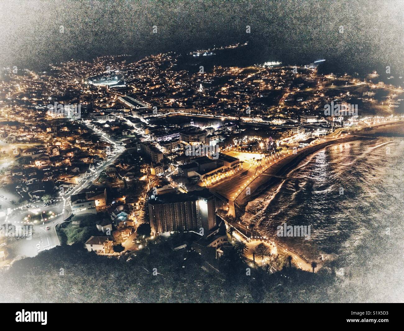 Semi-aerial view to the coastal town of Santa Cruz at night, Madeira, Portugal - Smartphone Captured Stock Image
