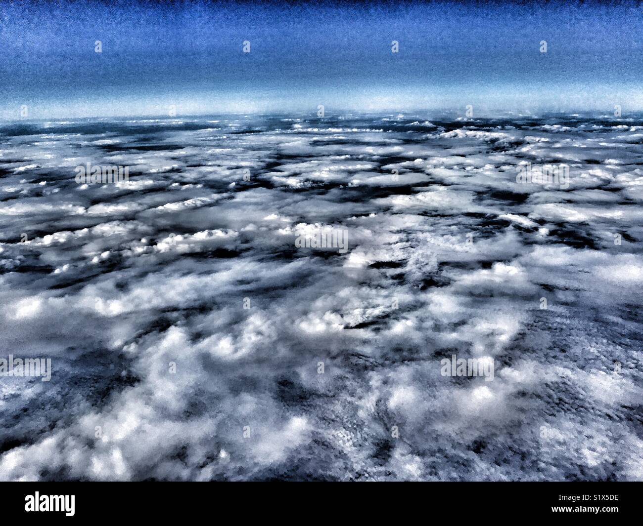 View through the window of an aeroplane flying above the clouds over the Atlantic Ocean - Smartphone Captured Stock Image