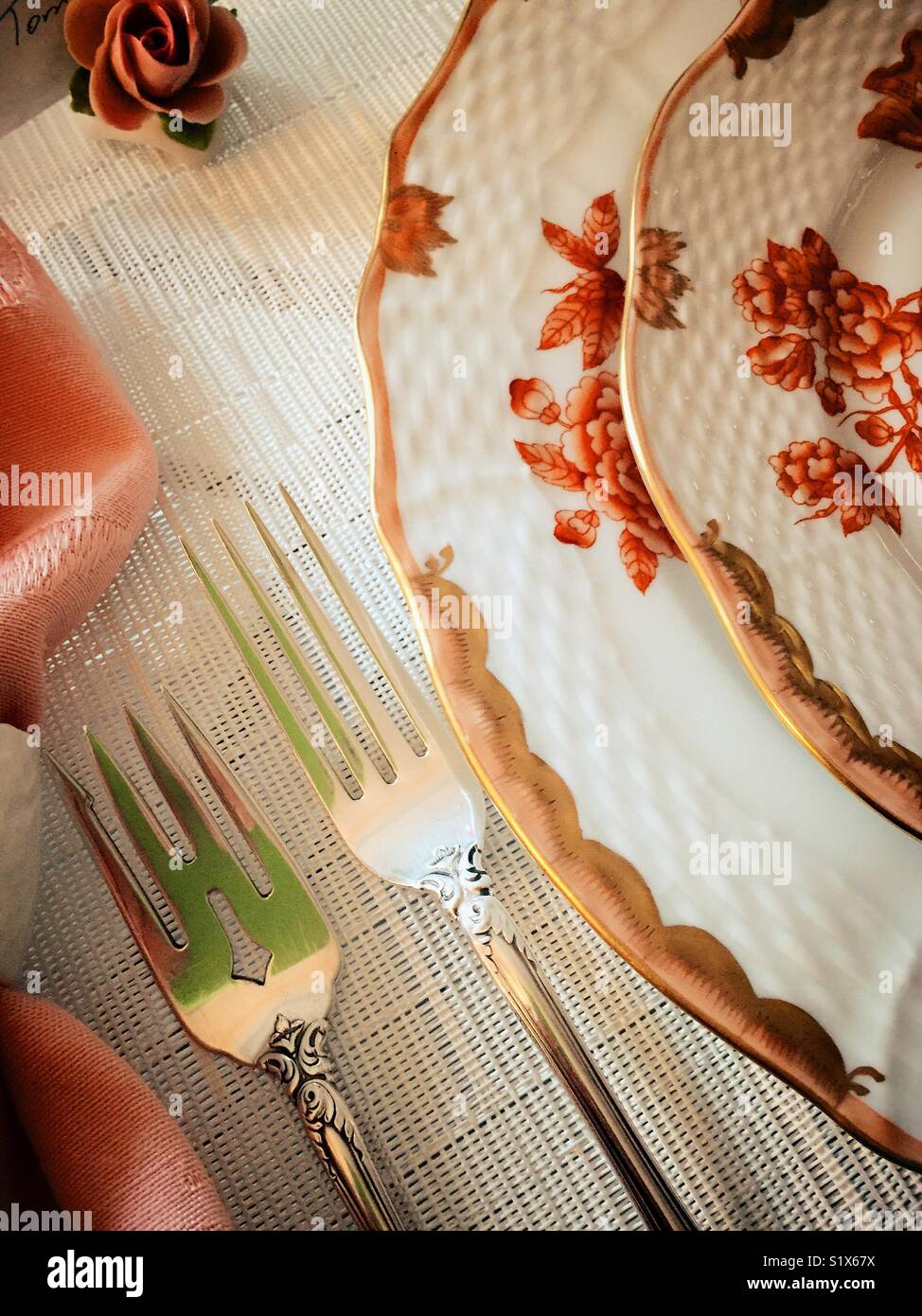 Table setting of fine china plates and sterling silver flatware Stock