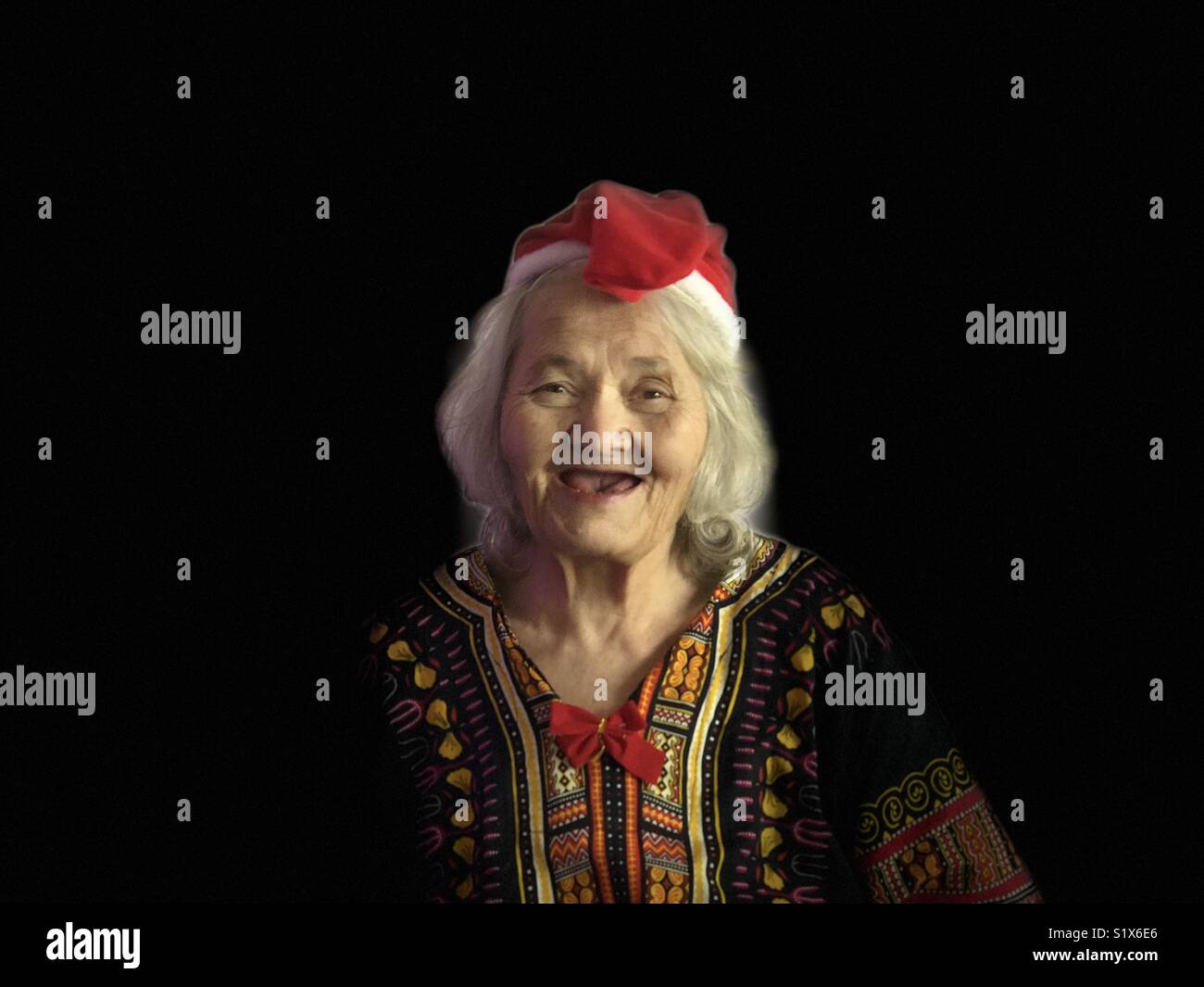 Portrait of smiling old woman with Christmas hat - Smartphone Captured Stock Image