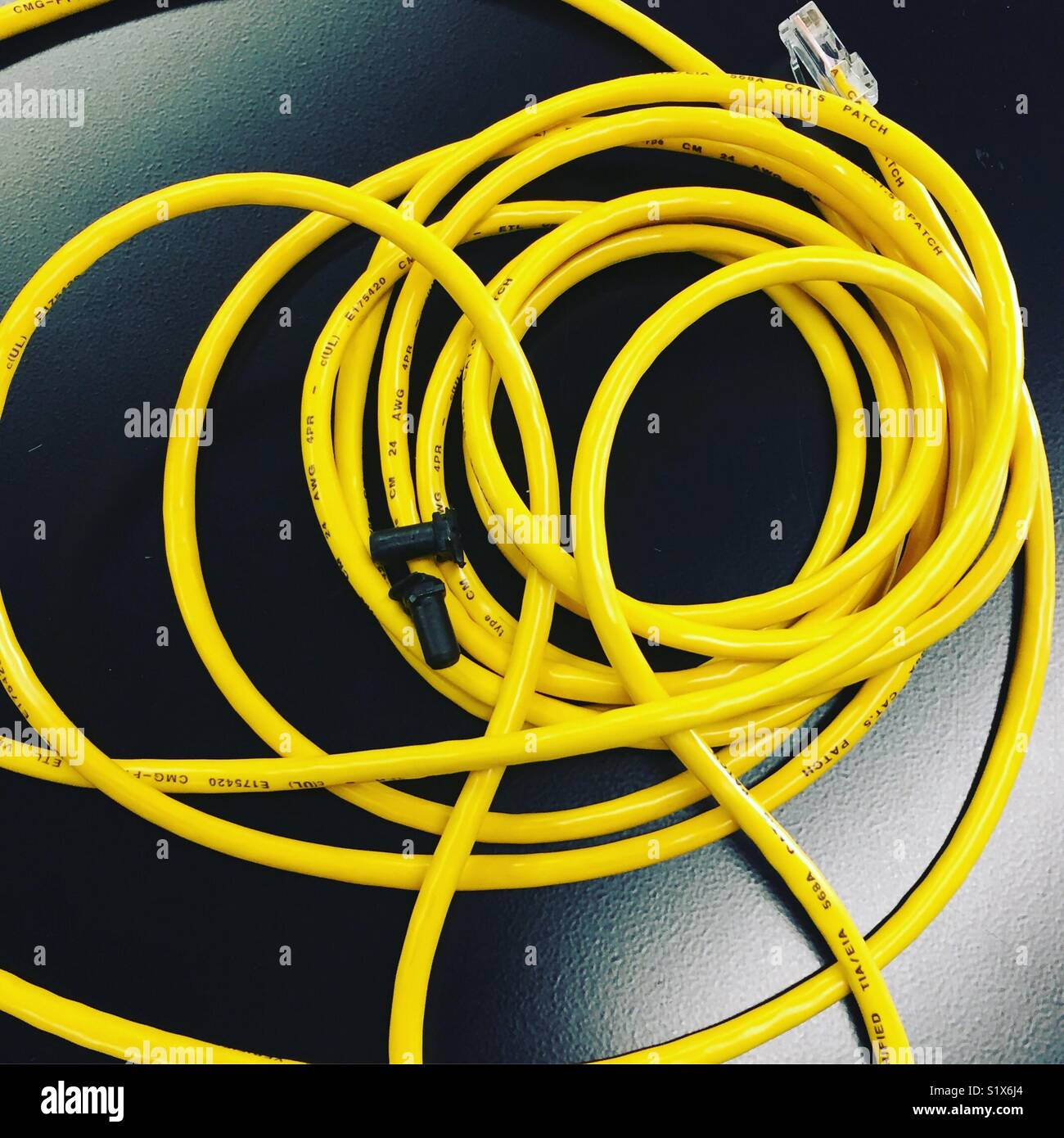 A yellow cable on black cabinet at work by K.R. Stock Photo