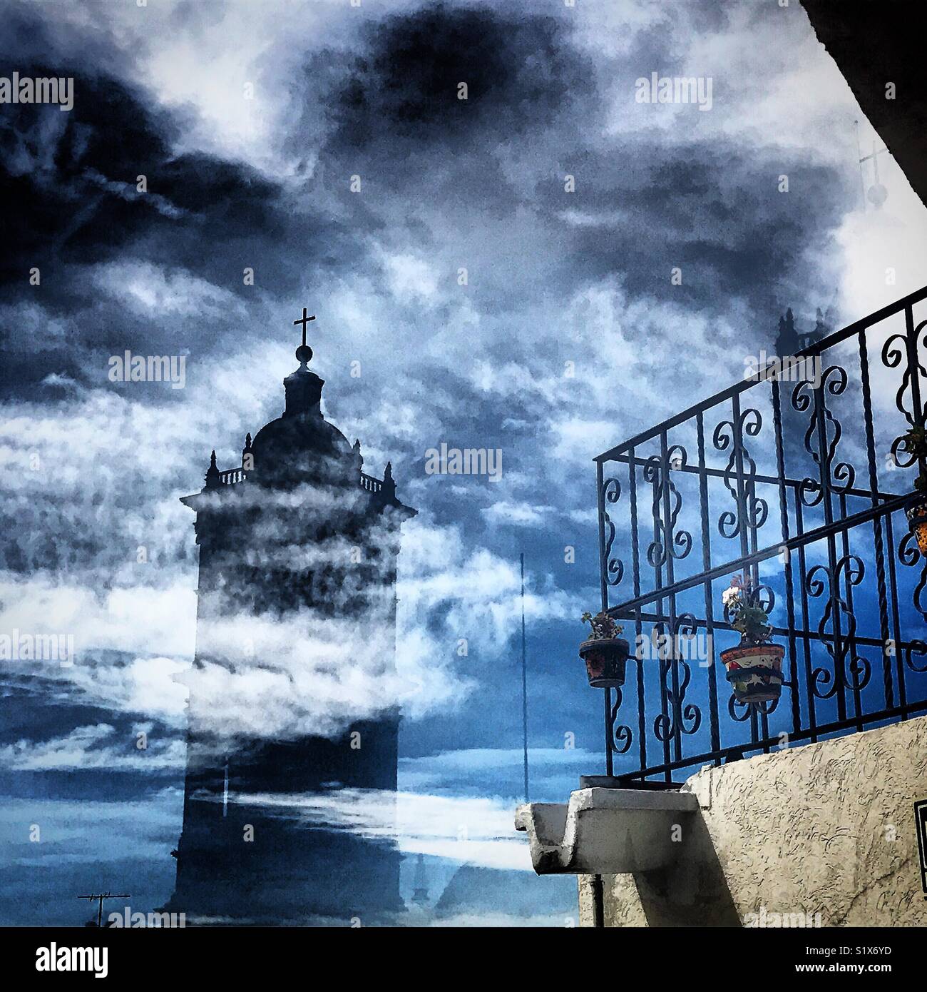 The reflection of a bell tower of the Catedral Metropolitana de Puebla in a window in Hotel Santiago, Puebla de los Angeles, Mexico - Smartphone Captured Stock Image