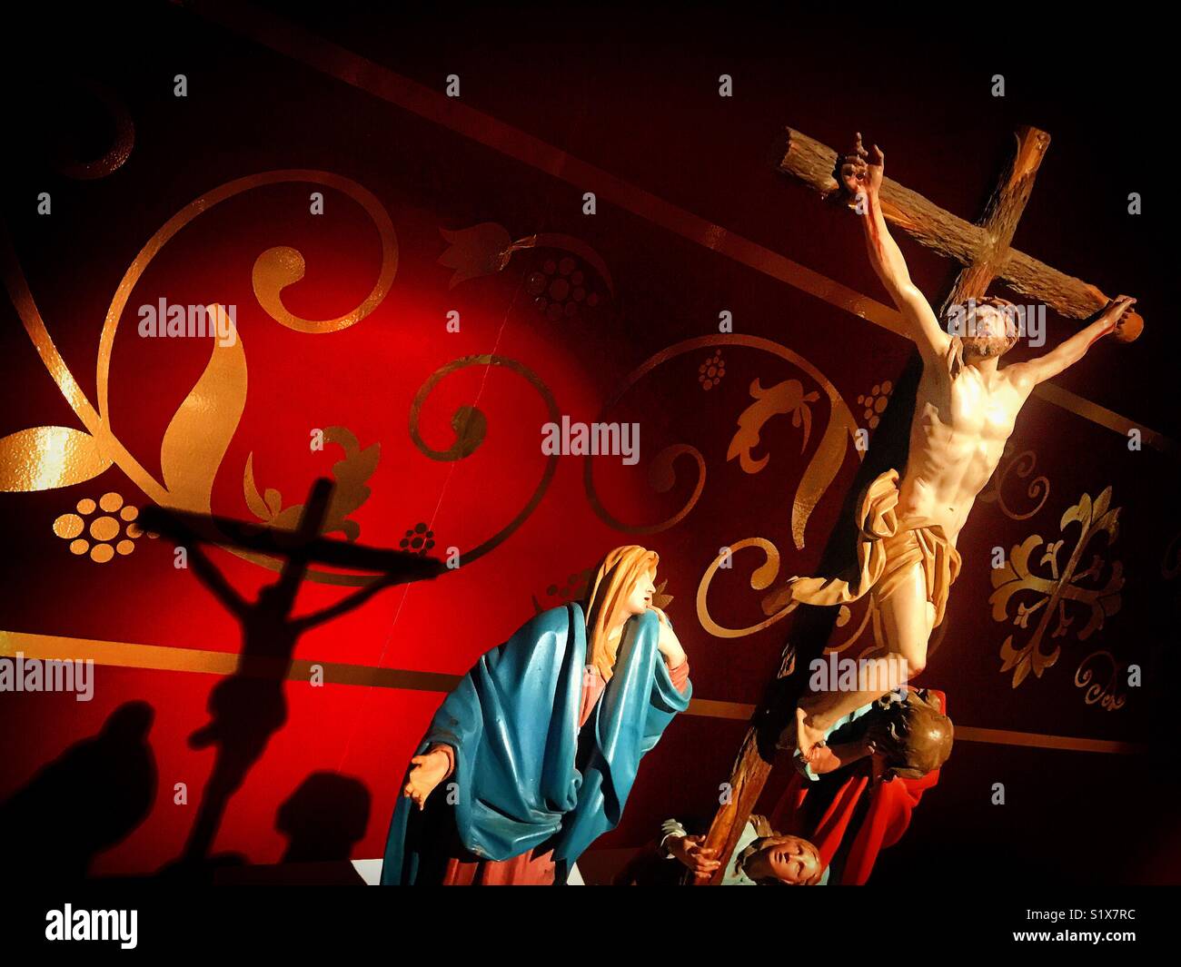 The shadow of a sculpture of Jesus Christ crucified is cast in Galeria Tesoros de la Catedral museum in Puebla de los Angeles, Mexico - Smartphone Captured Stock Image