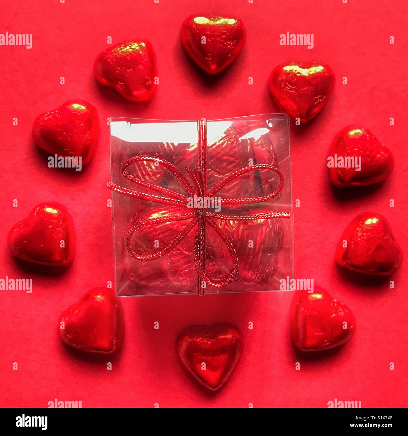 Valentine’s Day gift, Heart shaped chocolates wrapped in red foil. Flatlay photography, high angle view - Smartphone Captured Stock Image