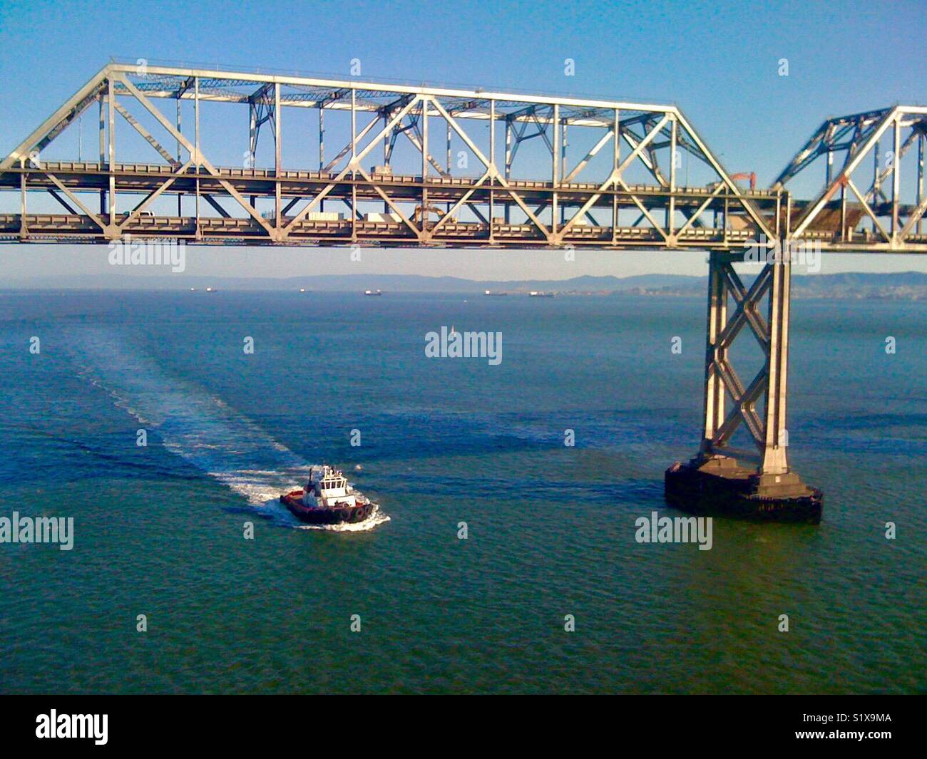 Tugboat passing under the old Bay Bridge, San Francisco Bay, California, USA. - Smartphone Captured Stock Image
