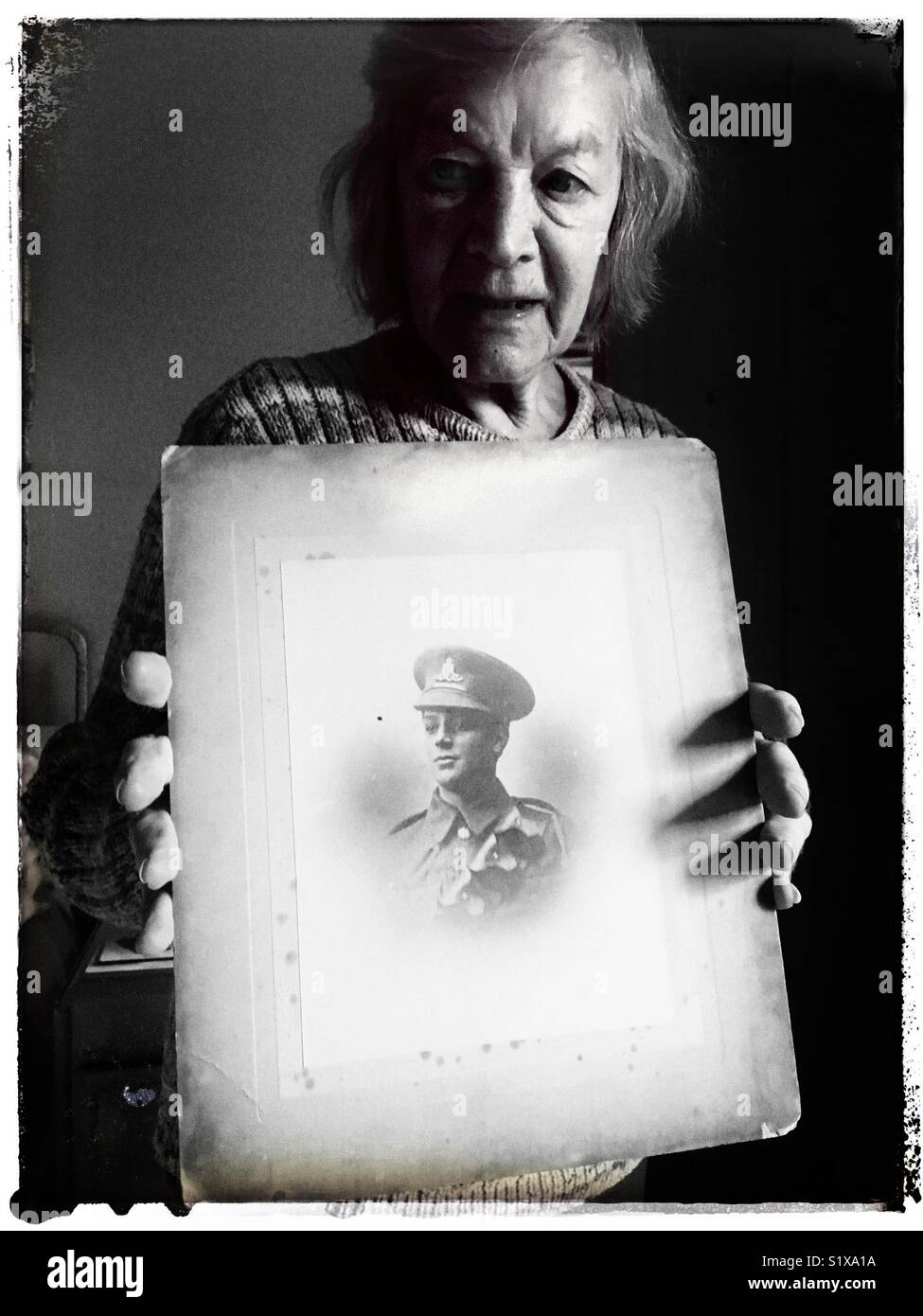 Jean Brown 86-Years old holding a photograph of her father taken in 1918 at the end of the First World War. - Smartphone Captured Stock Image