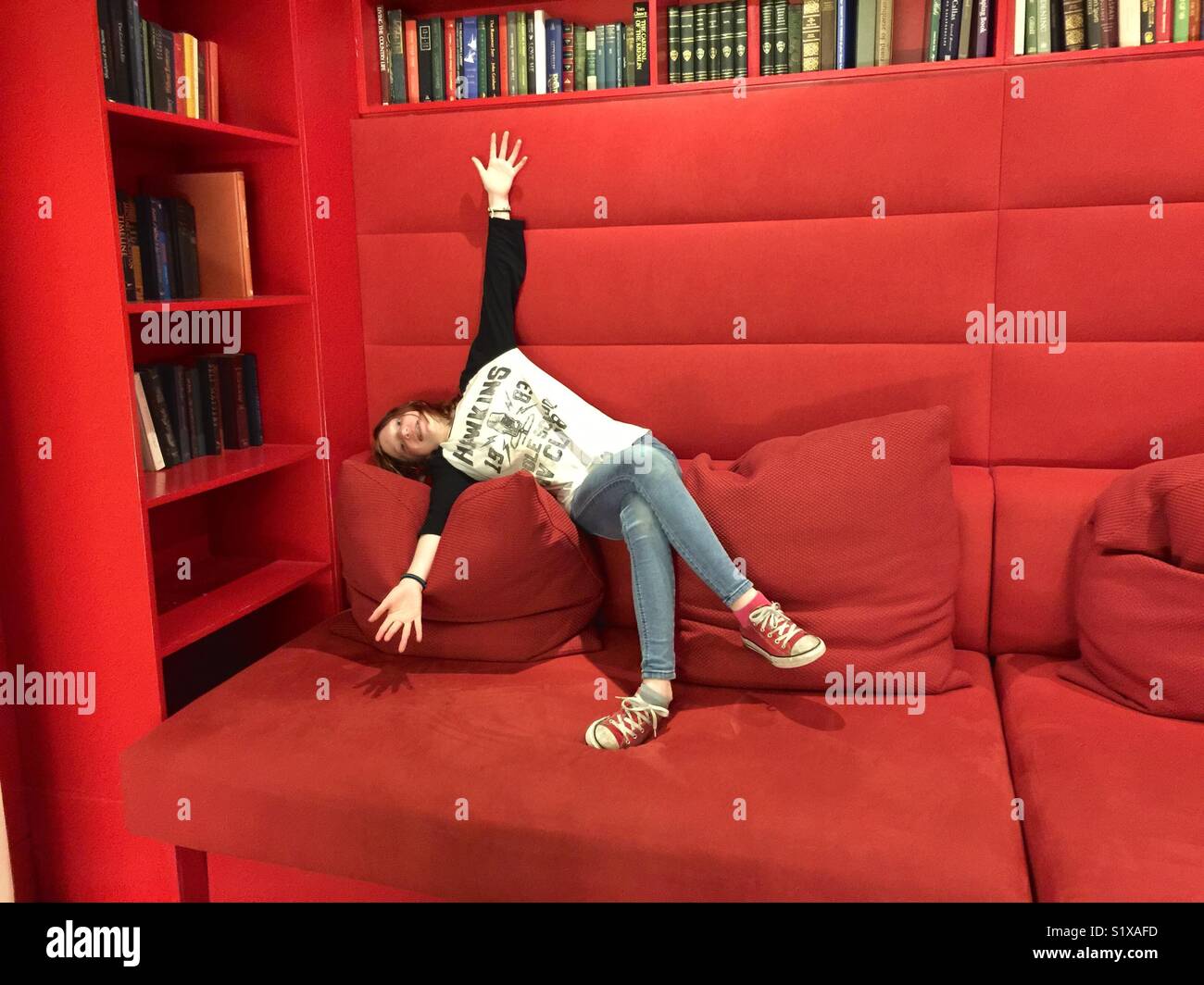 Girl on big red couch. Stock Photo