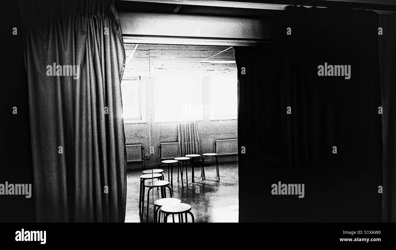 Row of empty stools reflected in mirror between curtains - Smartphone Captured Stock Image