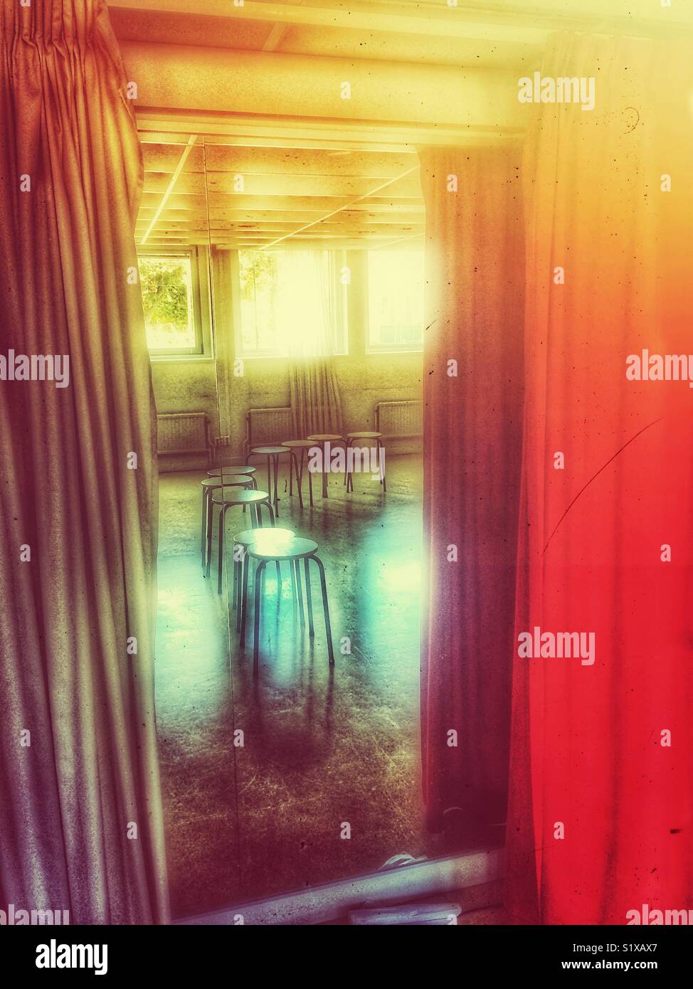 Row of empty stools reflected in mirror between curtains - Smartphone Captured Stock Image