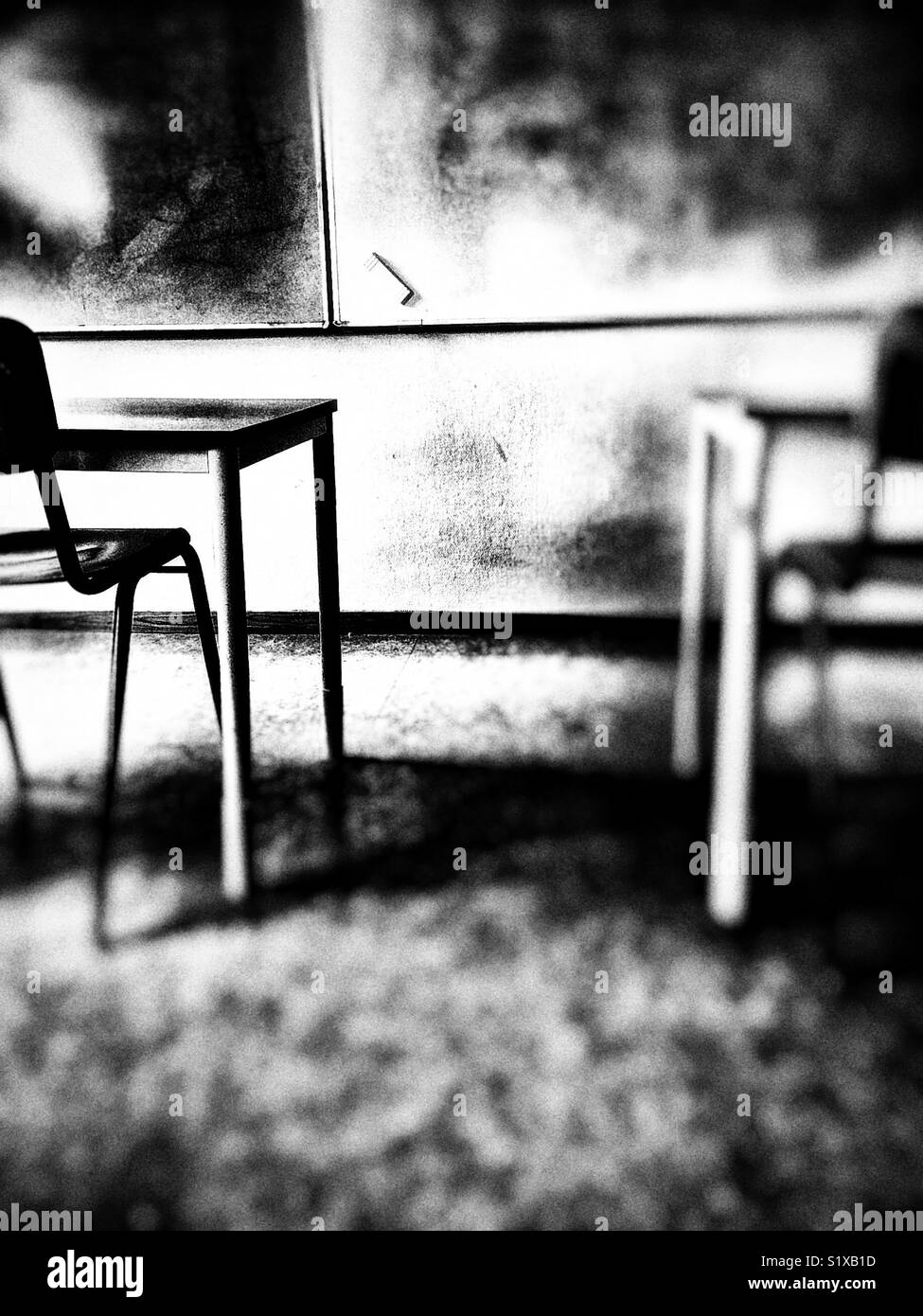 Empty classroom with whiteboard, eraser and tables and chairs Stock Photo