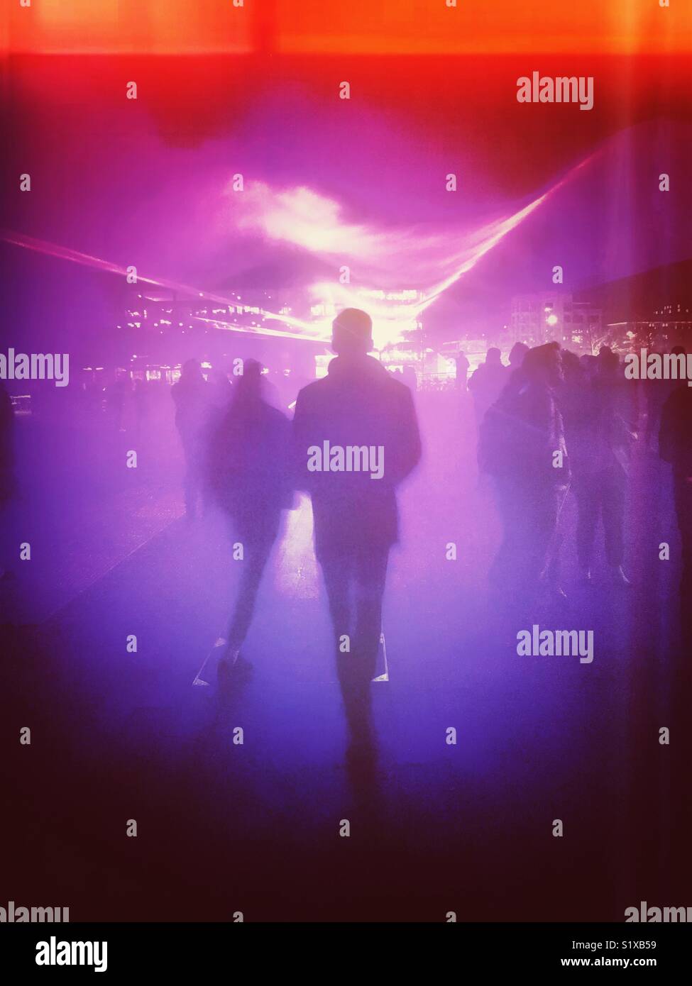 Abstract of people walking into a foggy lighting display - Smartphone Captured Stock Image