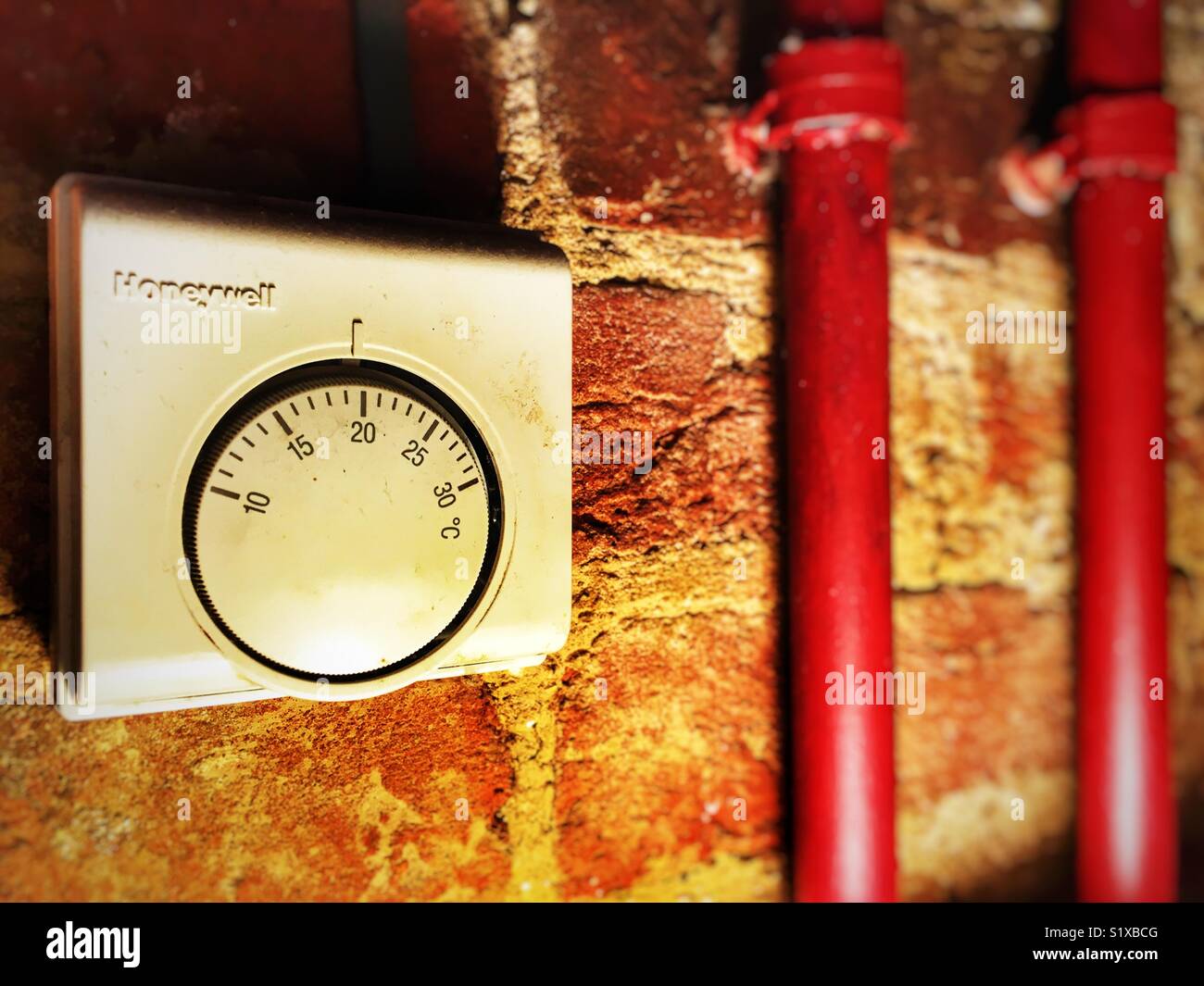 Honeywell thermostat and exposed water pipes - Smartphone Captured Stock Image