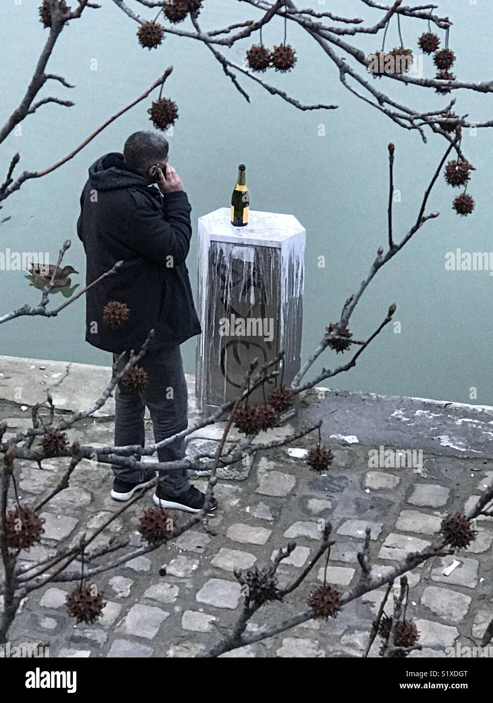 A man waiting for his love at a river with a bottle of Champagne ready - Smartphone Captured Stock Image