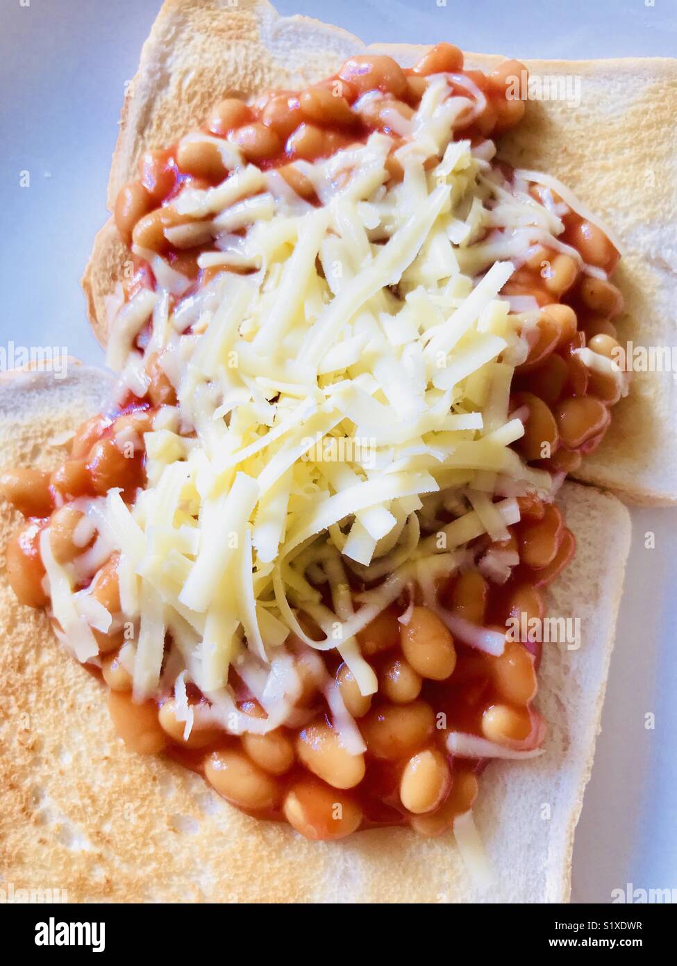 Beans on toast with grated cheese Stock Photo