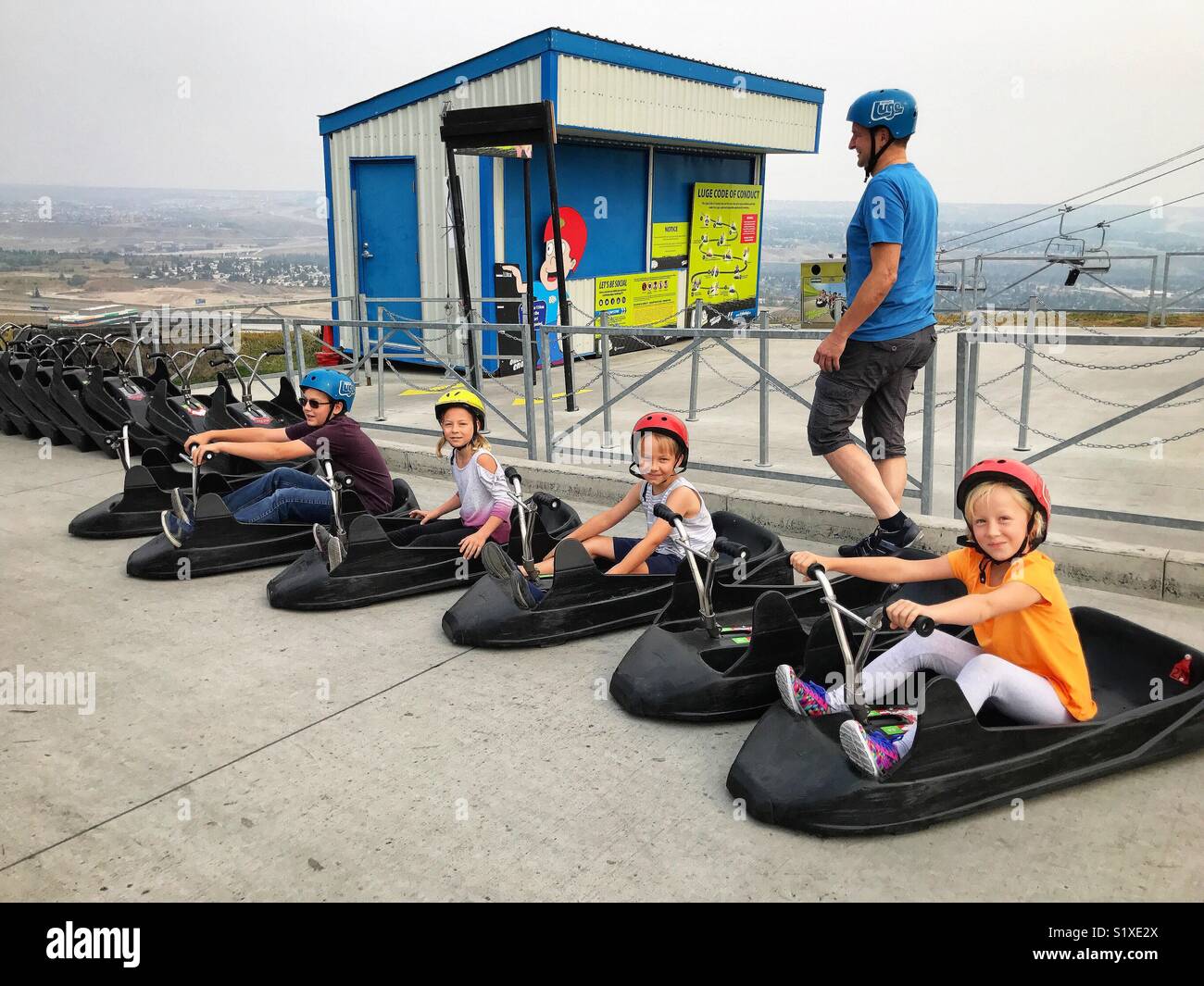 Four children prepare to ride the Skyline Luge in Calgary, Canada. Stock Photo
