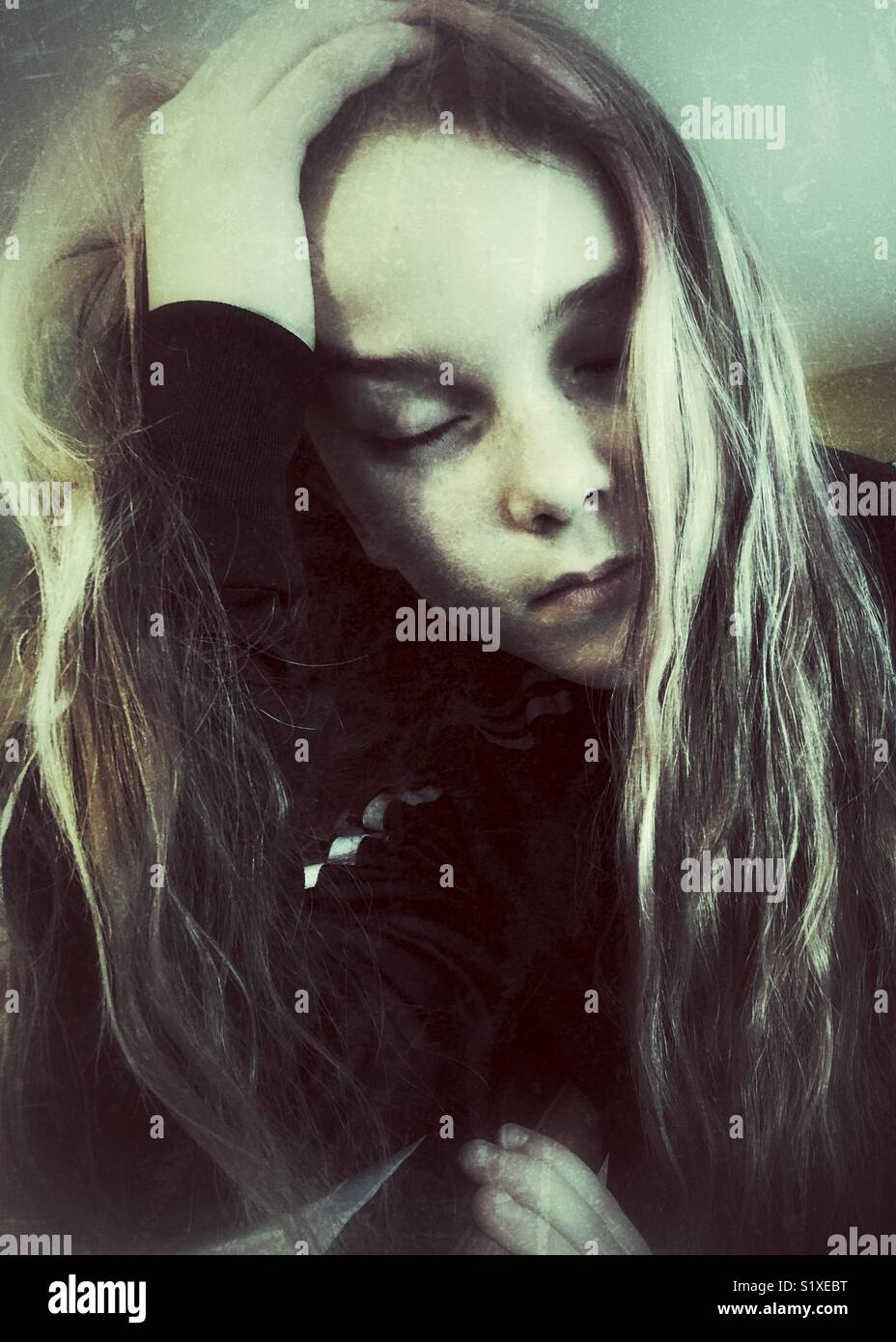 Creative portrait of girl holding head with hand in hair and eyes closed - Smartphone Captured Stock Image