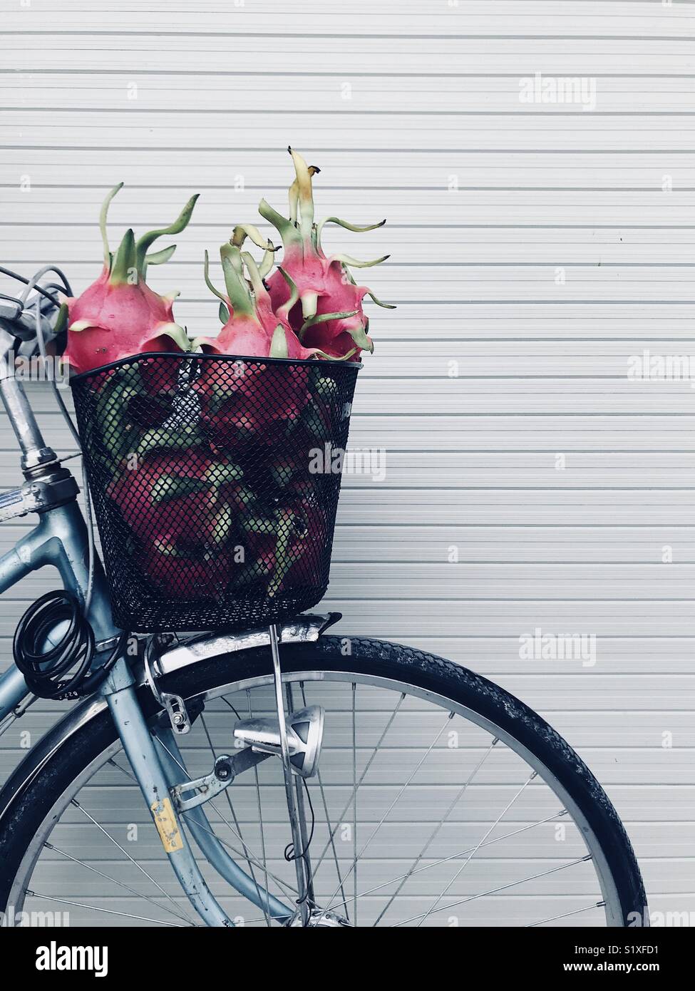 Vintage bicycle with full basket of exotic fruit against the wall Stock Photo Alamy