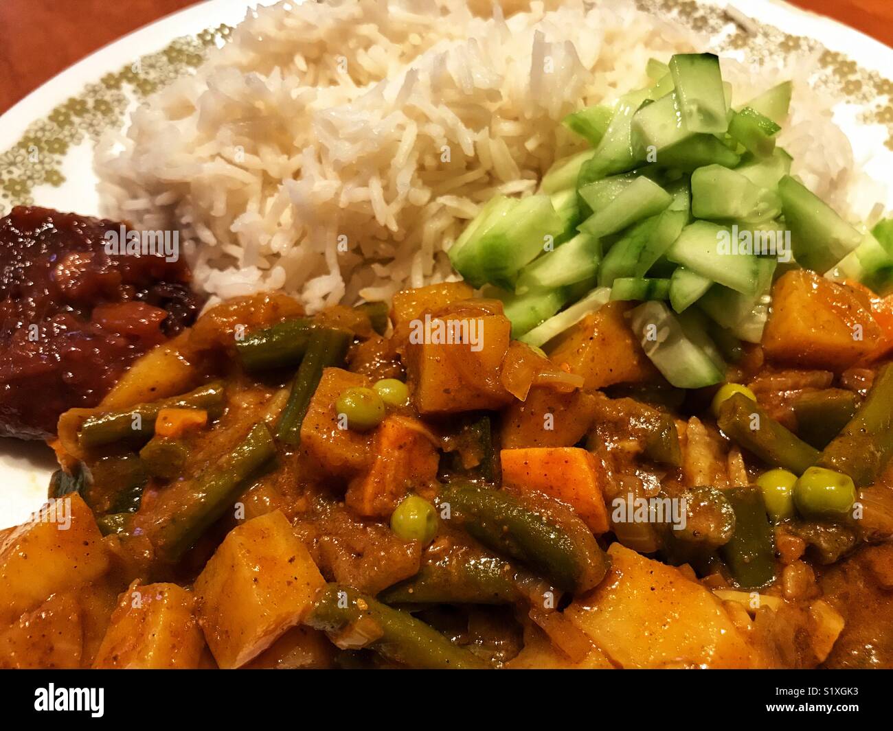 Vegetable curry, cucumber salad, lime pickle and rice on a plate - Smartphone Captured Stock Image