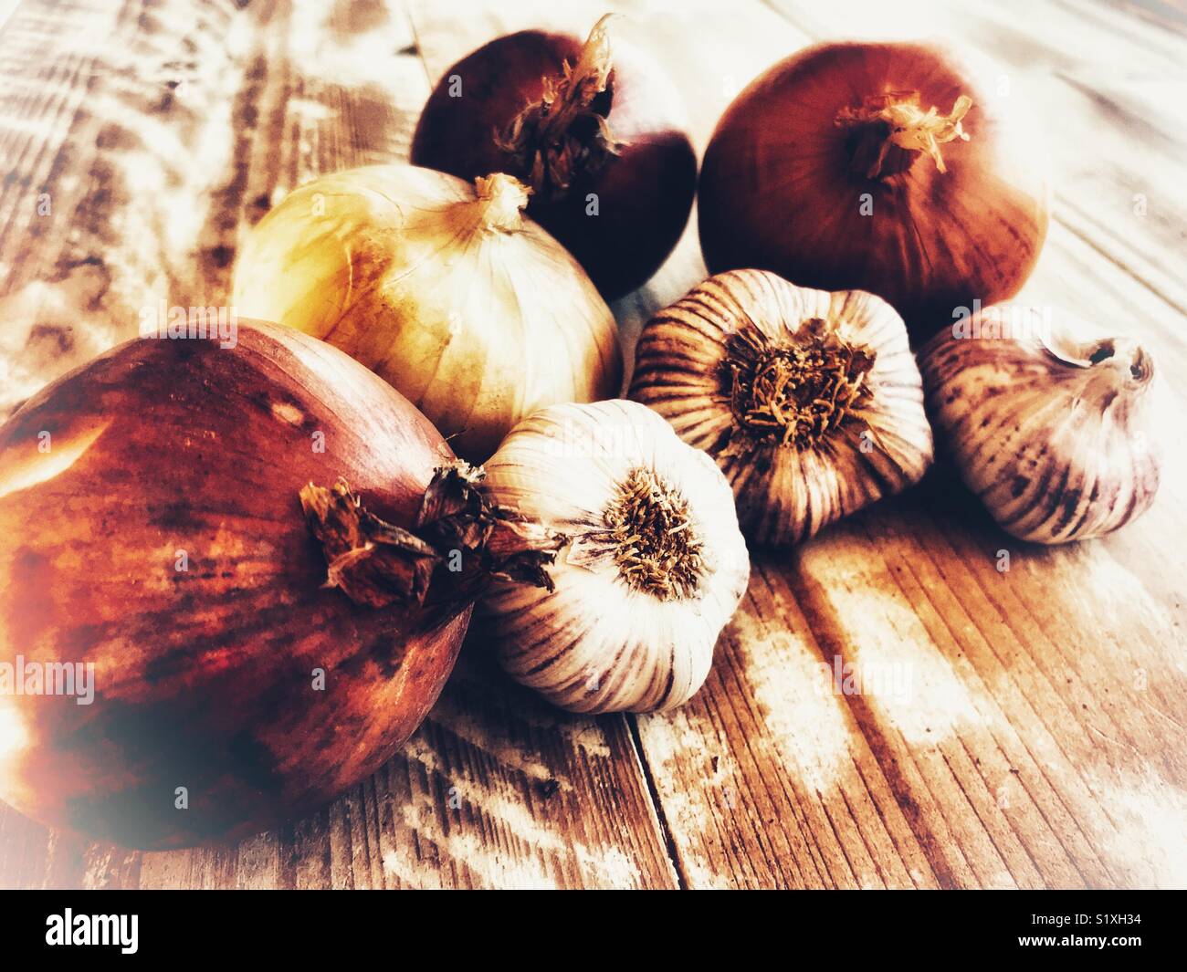 Variety of onions and garlic on a wooden table - Smartphone Captured Stock Image