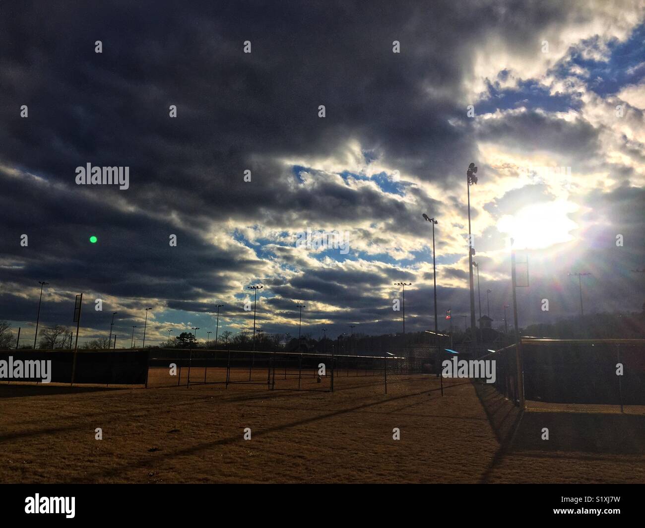 Seeing the light (sunlight breaking through heavy cloud cover, halogen lighting opposite side is lit where the clouds are still heavy) Stock Photo