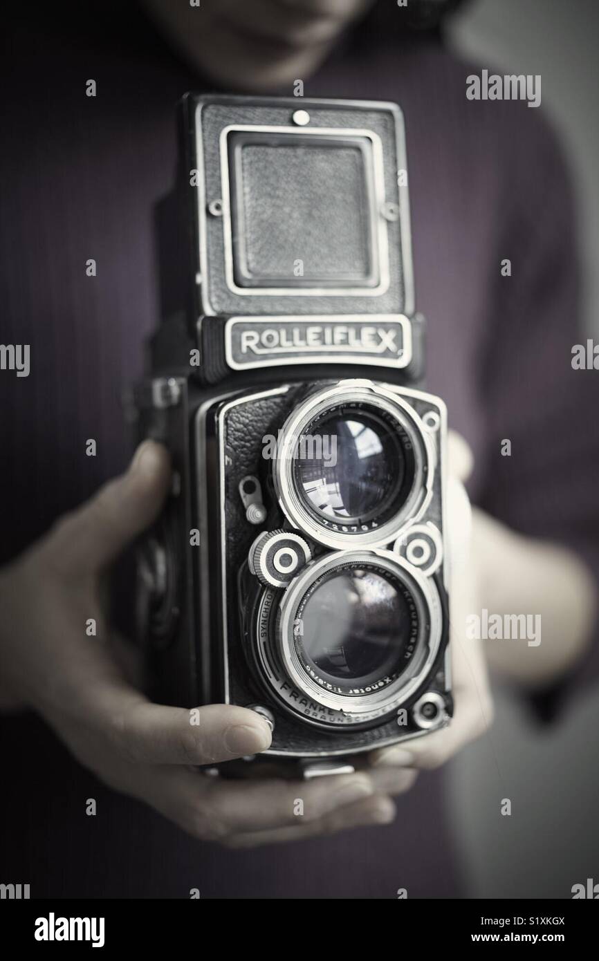 photographer holding a vintage Rolleiflex medium format camera. Stock Photo