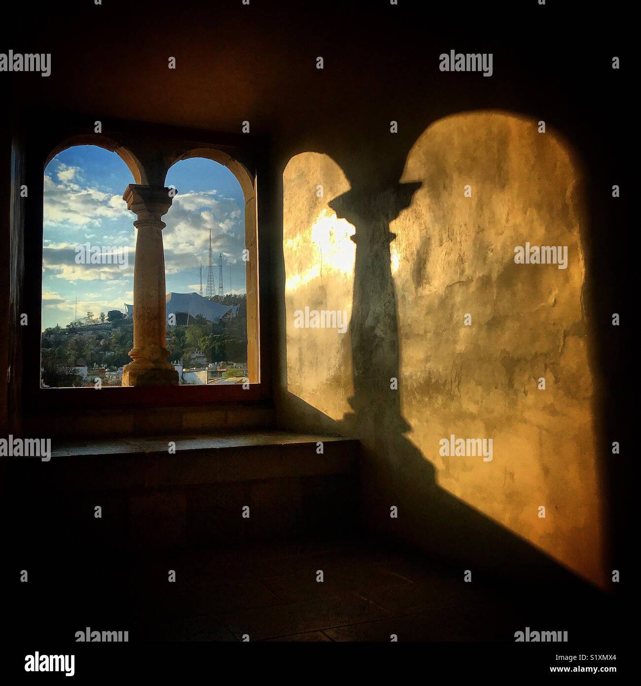 The shadow of a window with two arches is cast in Museo de las Culturas de Santo Domingo convent in Oaxaca, Mexico Stock Photo