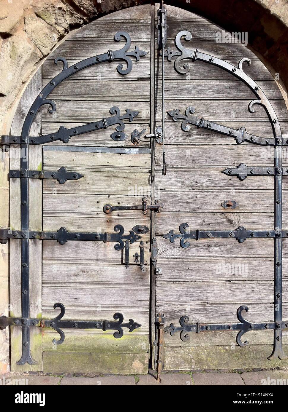 Historic medieval timber doorway with cast iron hinges, braces, and latches. Lord Leycester Hospital, Warwick - Smartphone Captured Stock Image