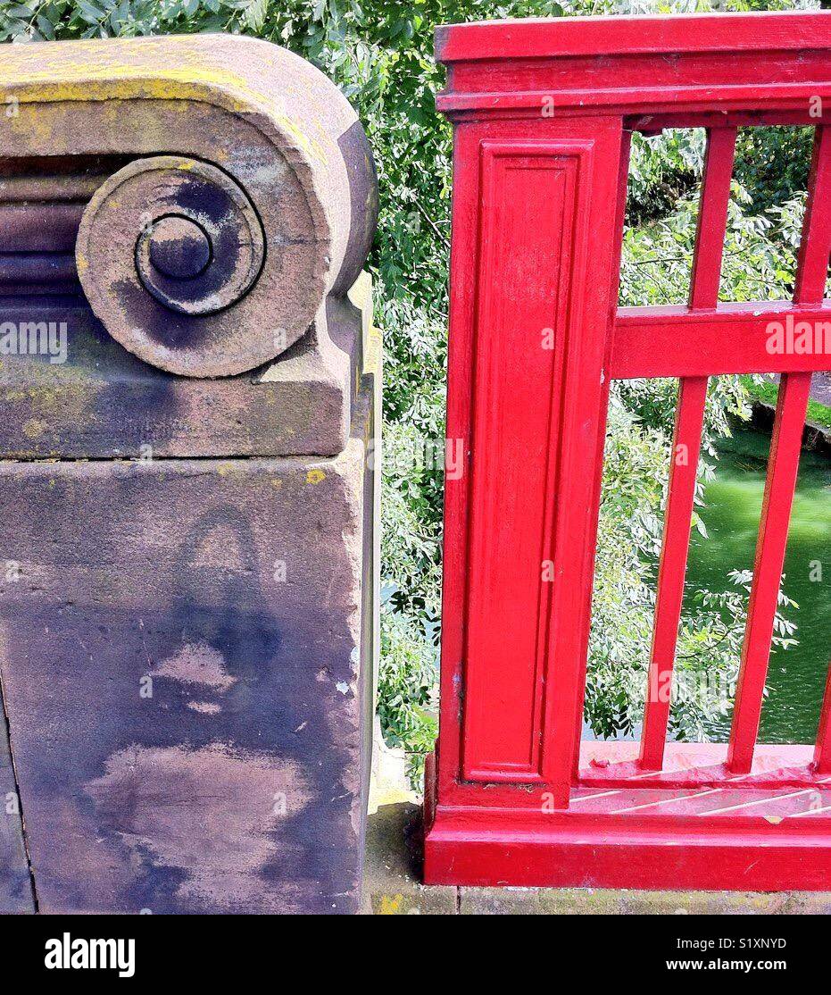 Red metal bridge meets carved stone wall - Smartphone Captured Stock Image