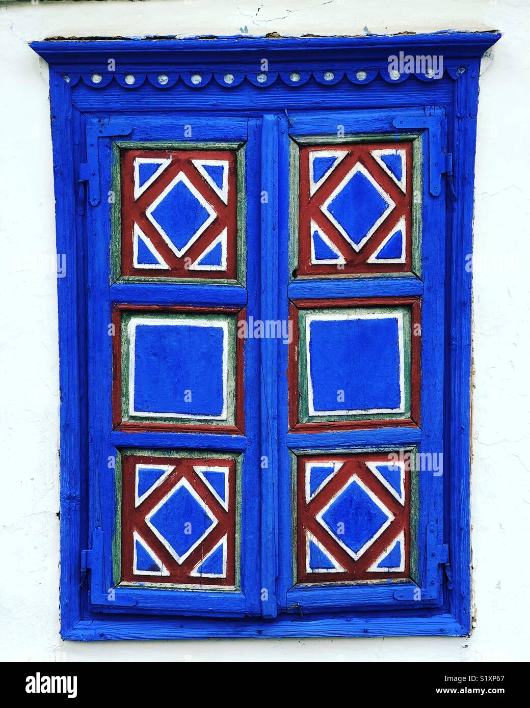 An old painted window shutter on a traditional Romanian house at the village museum, Bucharest - Smartphone Captured Stock Image