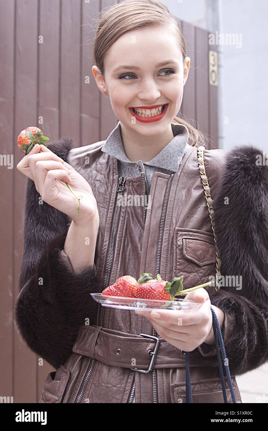 Fashion model eating strawberries after a show during fashion week - Smartphone Captured Stock Image