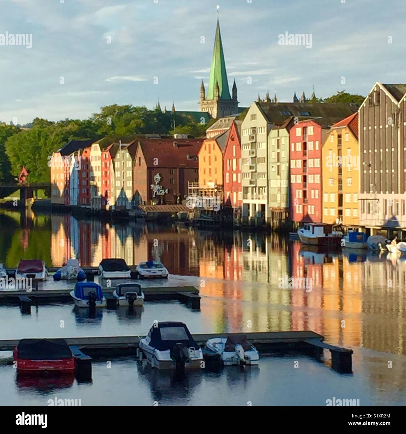Nidelva river and Nidaros domen in background, Trondheim, Norway. Old fishing warehouse in foreground. Stock Photo