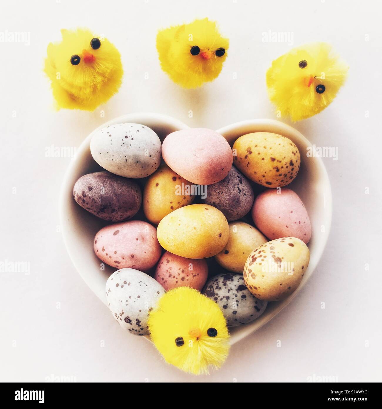 Chocolate Easter eggs in a ceramic heart shaped dish with tiny Easter