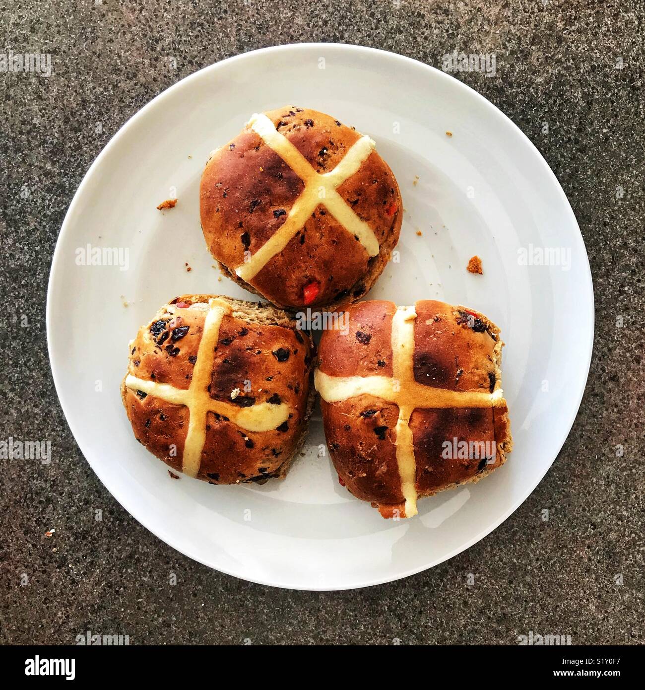 Toasted hot cross buns on a white plate, ready for eating Stock Photo