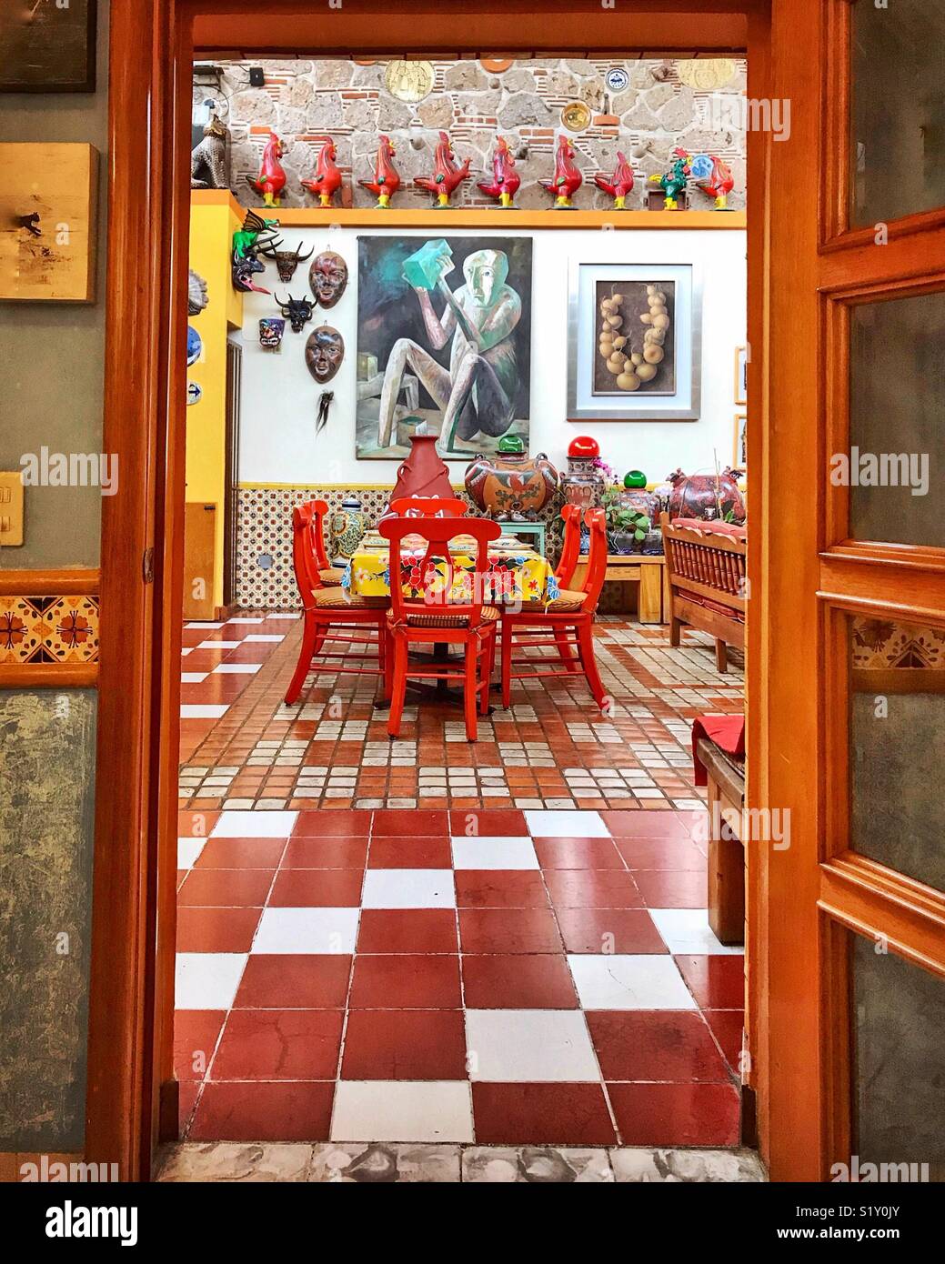 Charming and colorful breakfast table at La Casa de las Flores in Tlaquepaque, Mexico is surrounded by a wonderful variety of art and pottery. Stock Photo