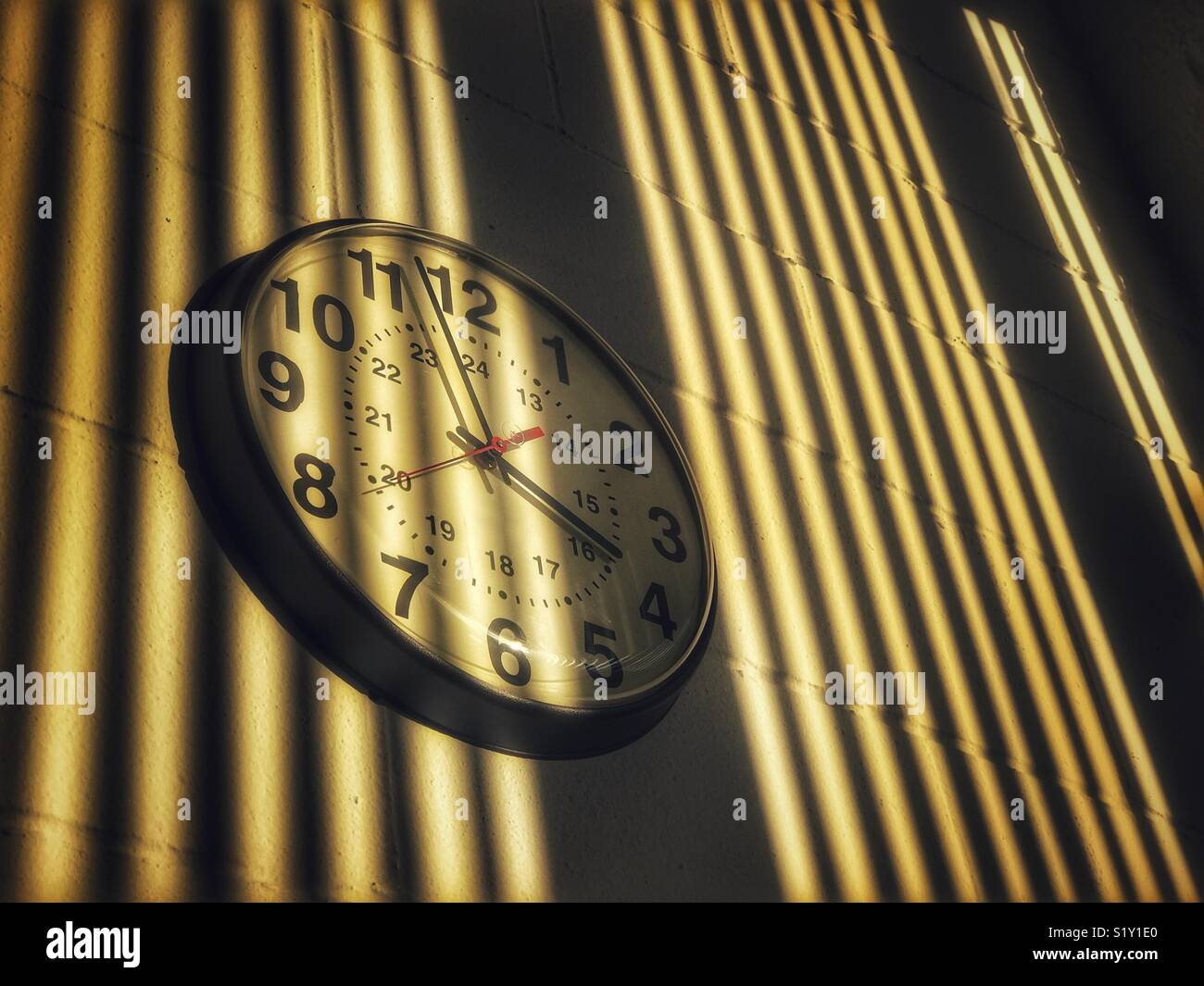Institutional type clock on wall with shadows - Smartphone Captured Stock Image