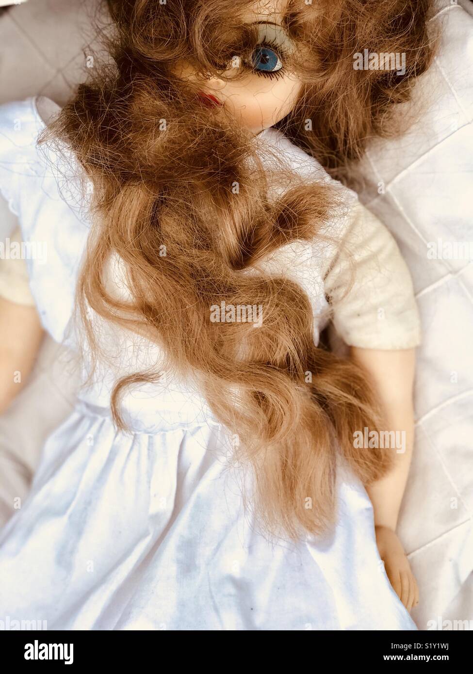 A high angle of a creepy old doll with disheveled hair sitting in the  garden Stock Photo  Alamy