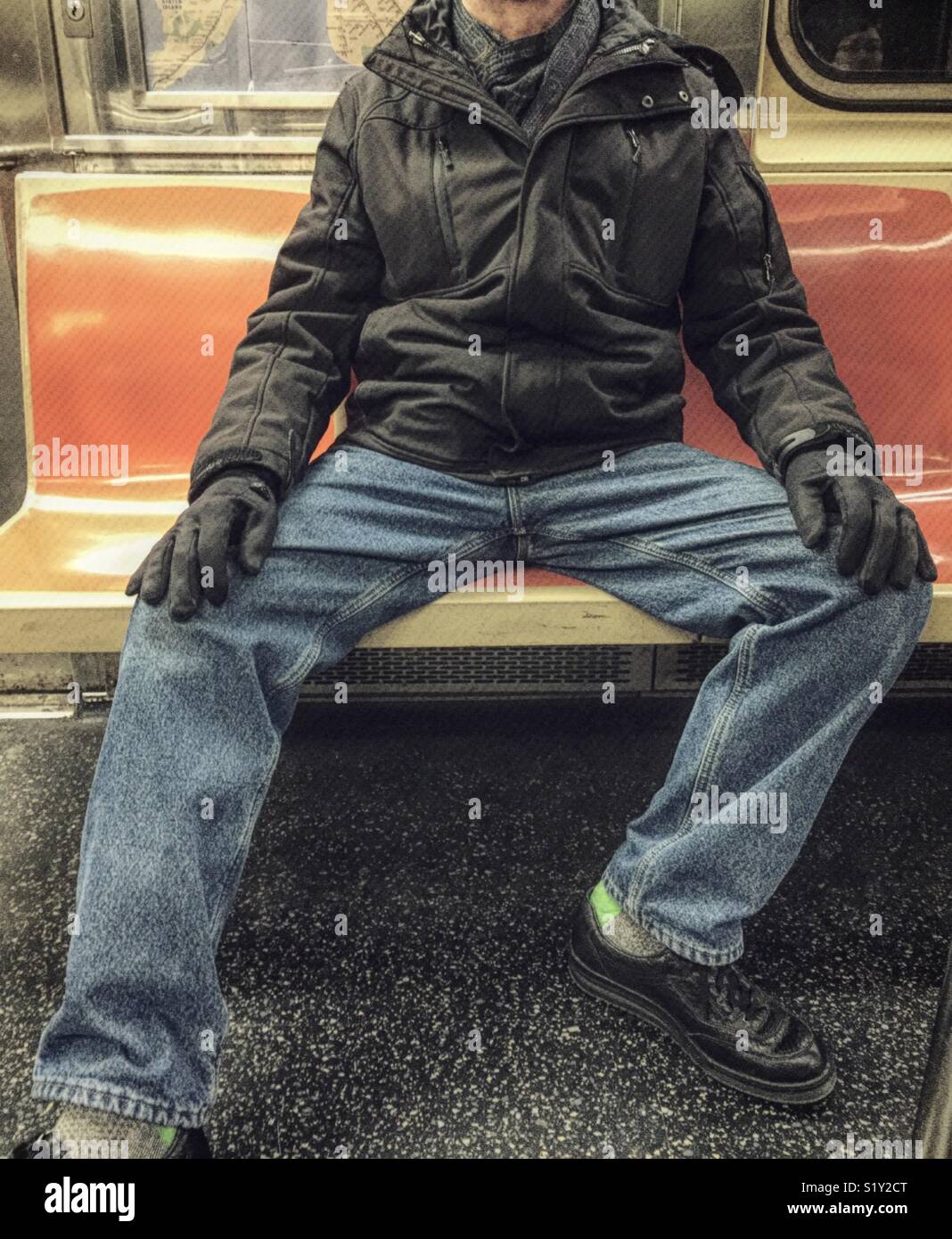 Adult male Hogging seats on New York City subway, USA Stock Photo