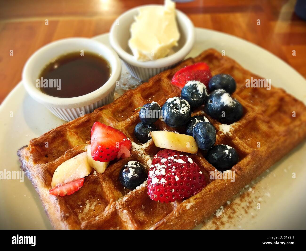 A waffle with fruit, butter, and maple syrup Stock Photo Alamy
