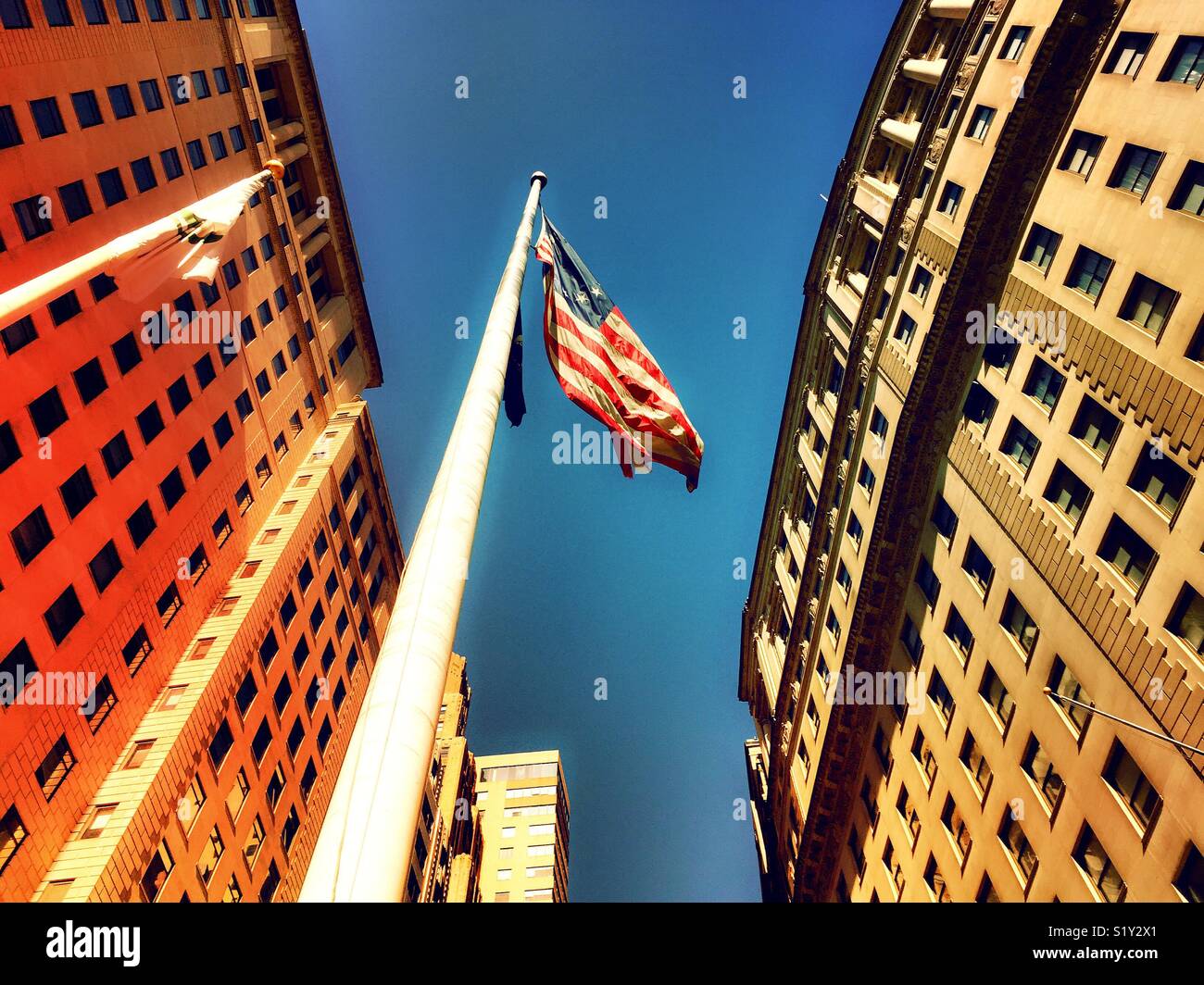 American flag waving at top of tall flagpole, Manhattan, New York City, USA - Smartphone Captured Stock Image