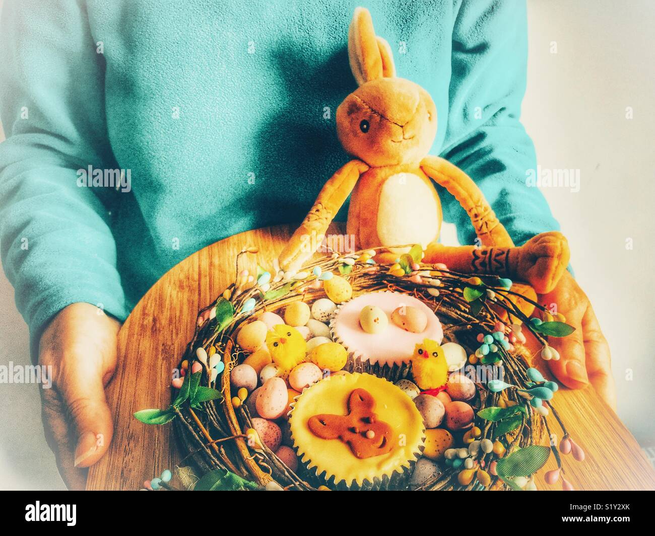 Woman holding a decorative tray of Easter eggs and cupcakes, Easter special treats - Smartphone Captured Stock Image