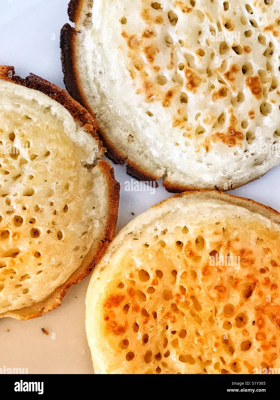 Three buttered, toasted English crumpets Stock Photo Alamy