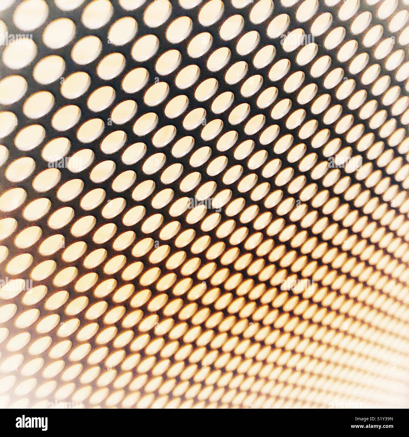 Abstract metallic background with holes blurring together in the distance. - Smartphone Captured Stock Image
