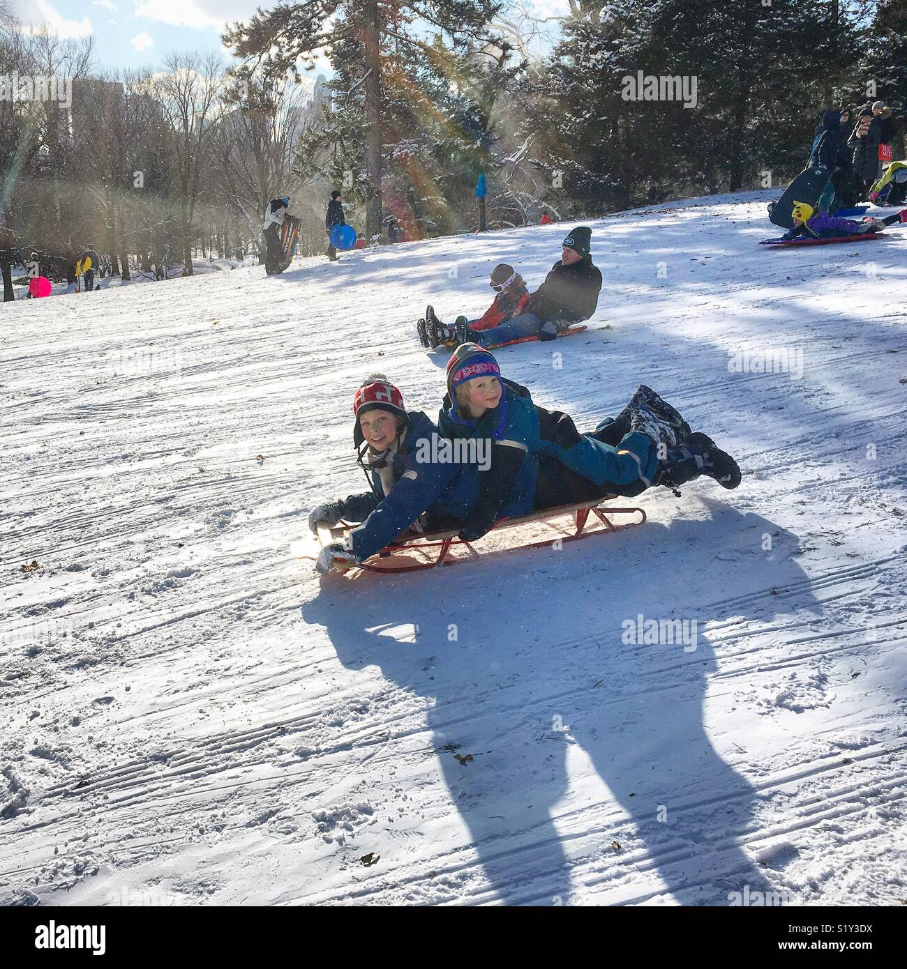 Children going down the hill on a sled Stock Photo Alamy