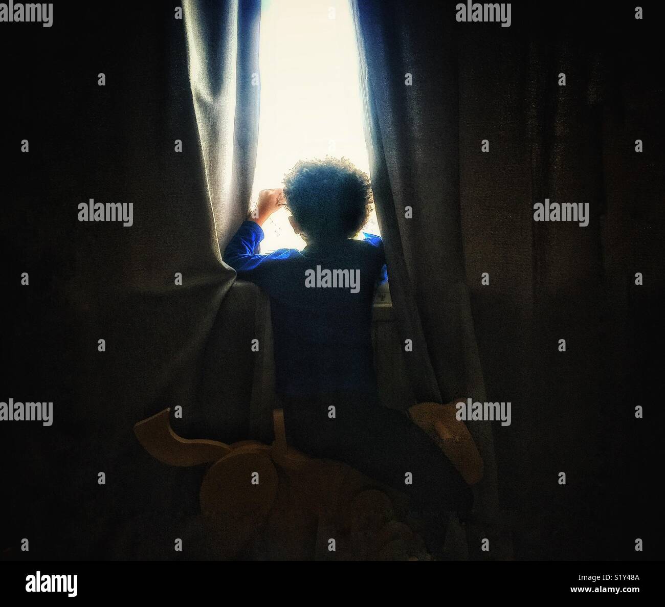 A boy looking out of a window. - Smartphone Captured Stock Image