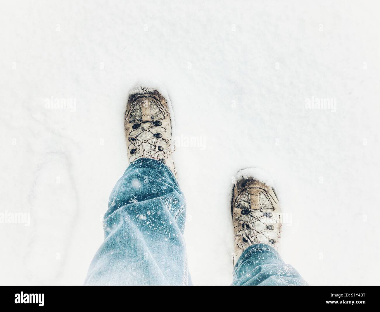 POV blue jeans, hiking boots in snow, during a blizzard, March 2018, Storm Emma in Sherborne, Dorset, England - Smartphone Captured Stock Image