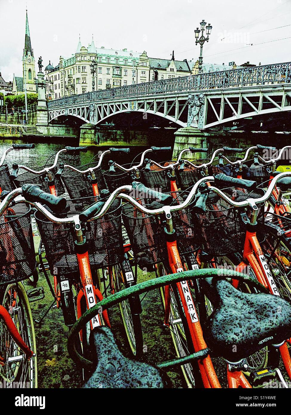 Rain soaked rental bikes next to Djurgardsbron (Djurgarden Bridge), Stockholm, Sweden, Scandinavia - Smartphone Captured Stock Image